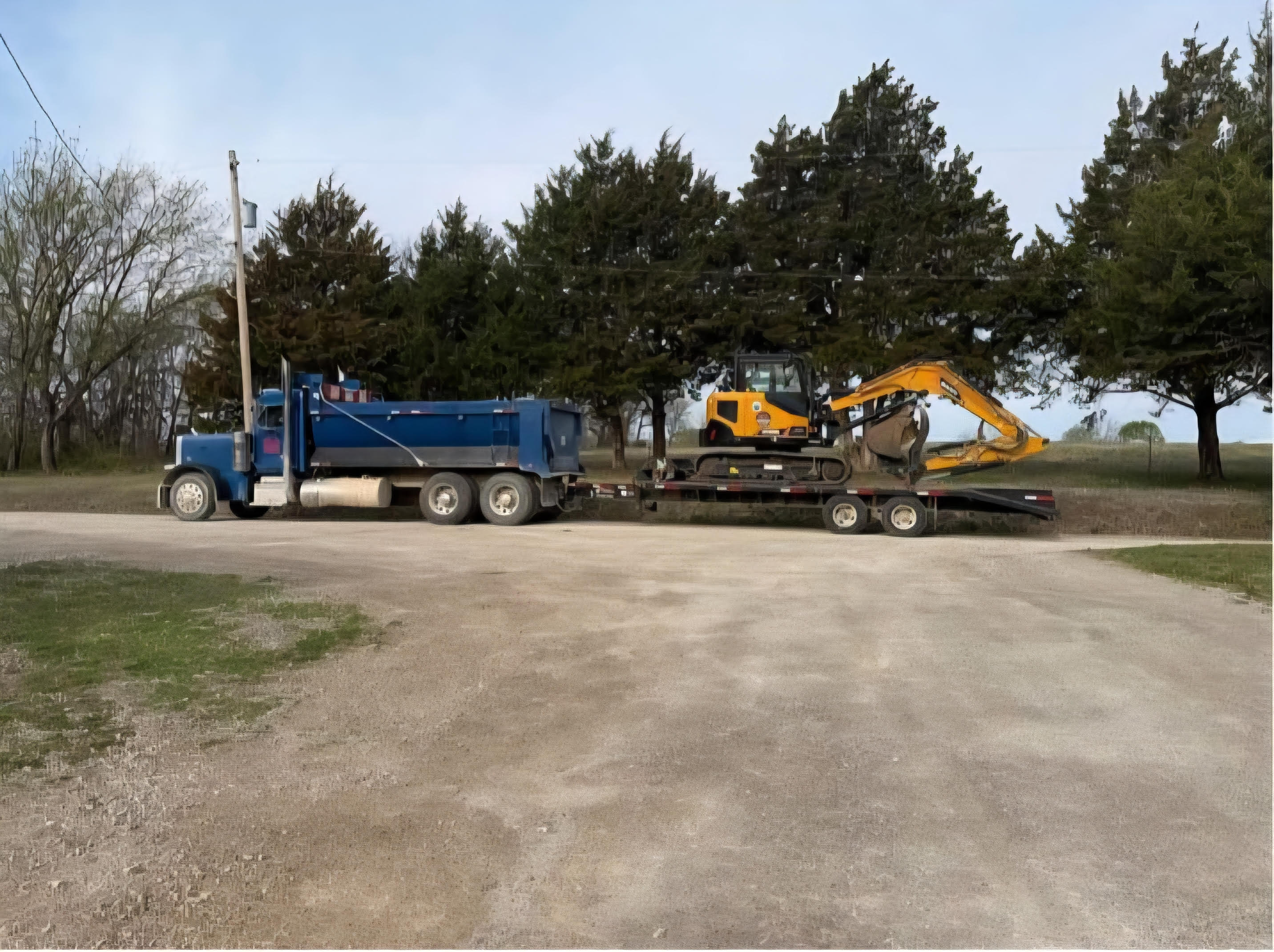 K & M Industries truck hauling excavator